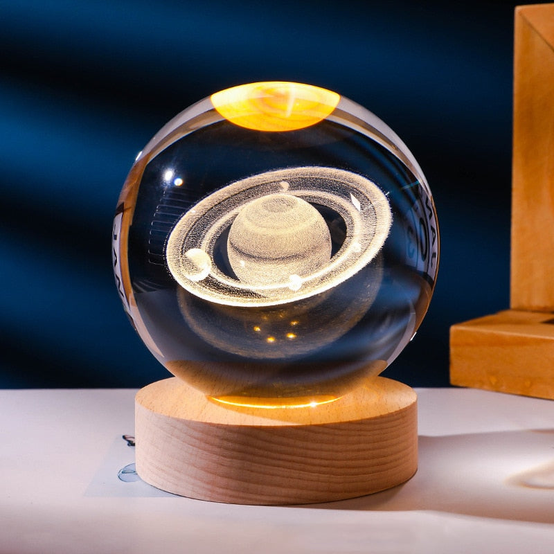 Luminária bola de cristal 3D com galáxia iluminada em luz amarela quente e base de madeira
