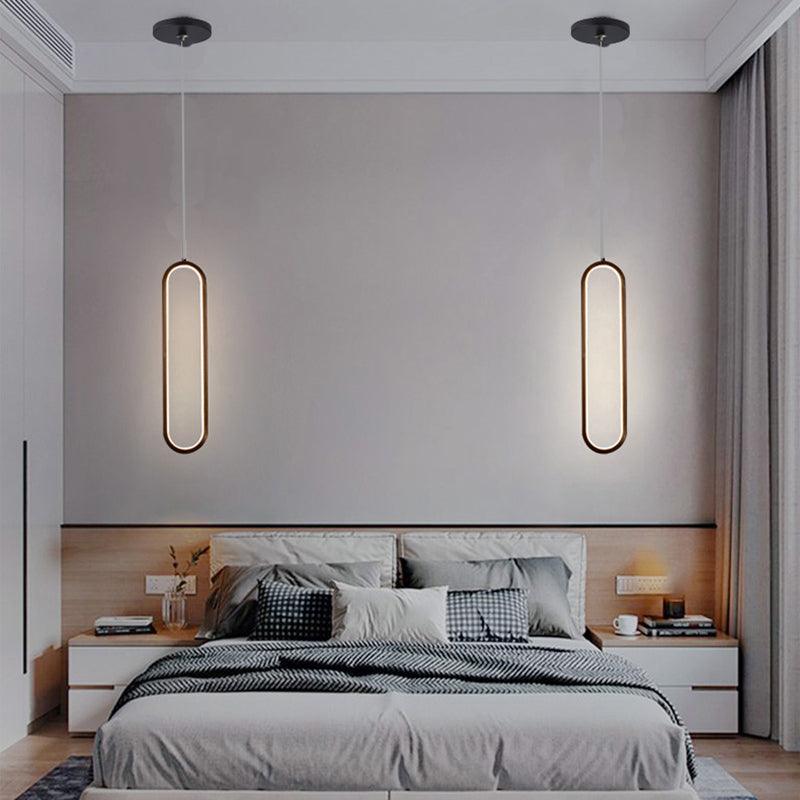 Pendente LED oval preto de 18W com luz branco quente 3000K instalado ao lado da cama